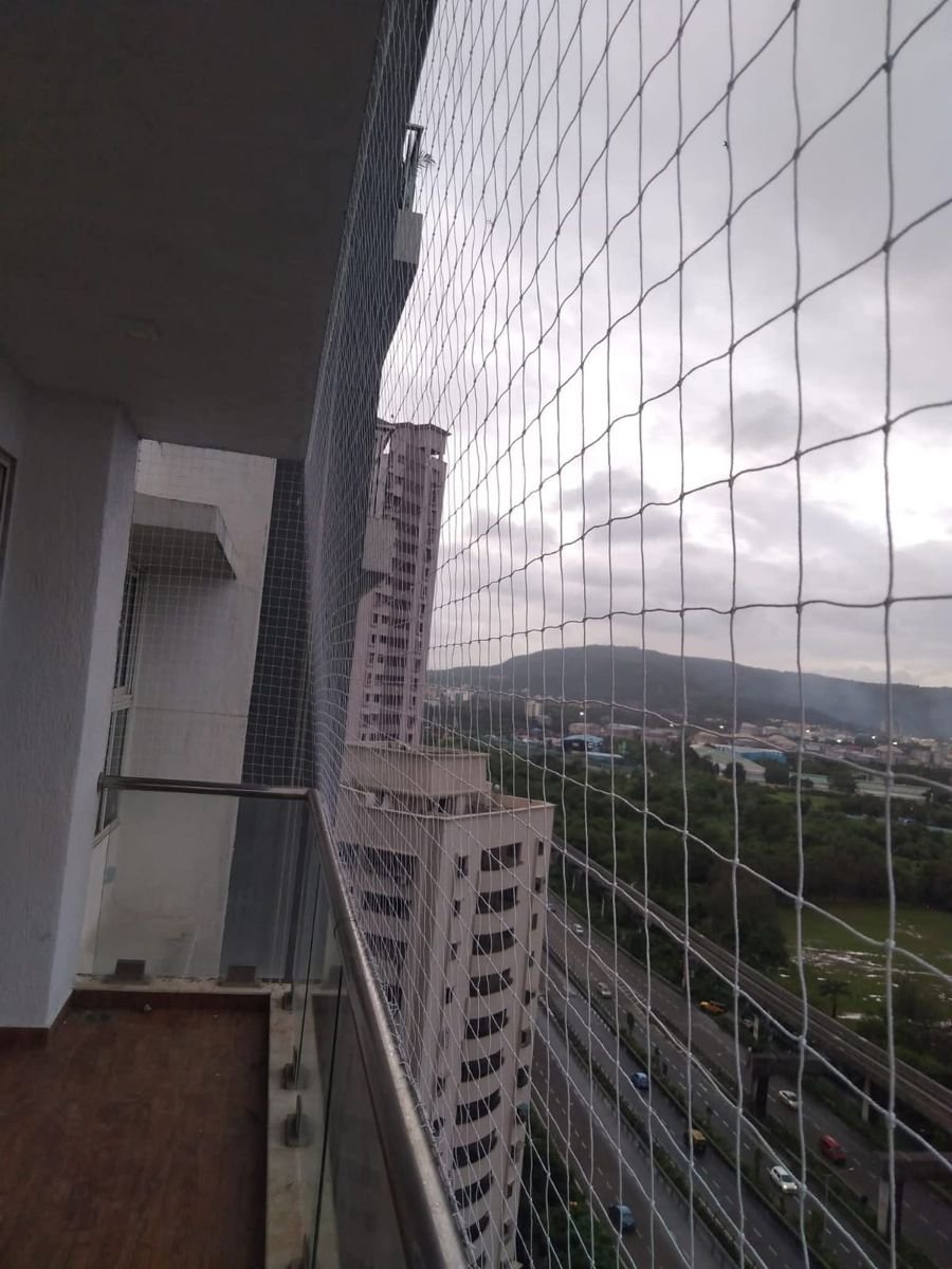 White balcony safety net fitted on a high-rise apartment balcony